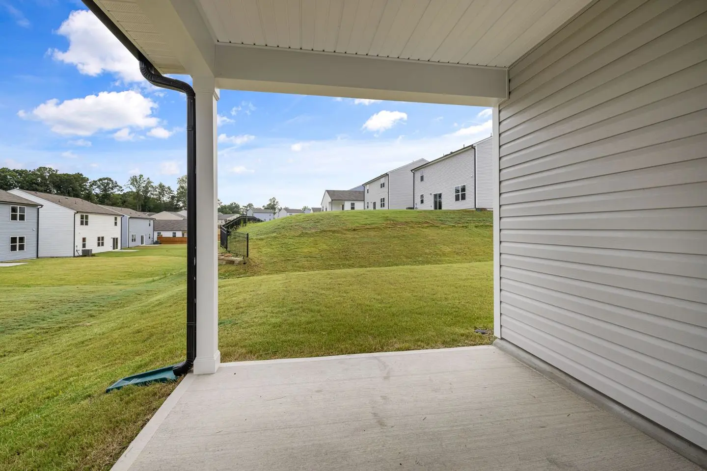 Plain concrete patio beside a covered porch, representative use context